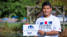 Veteran holding text to donate sign